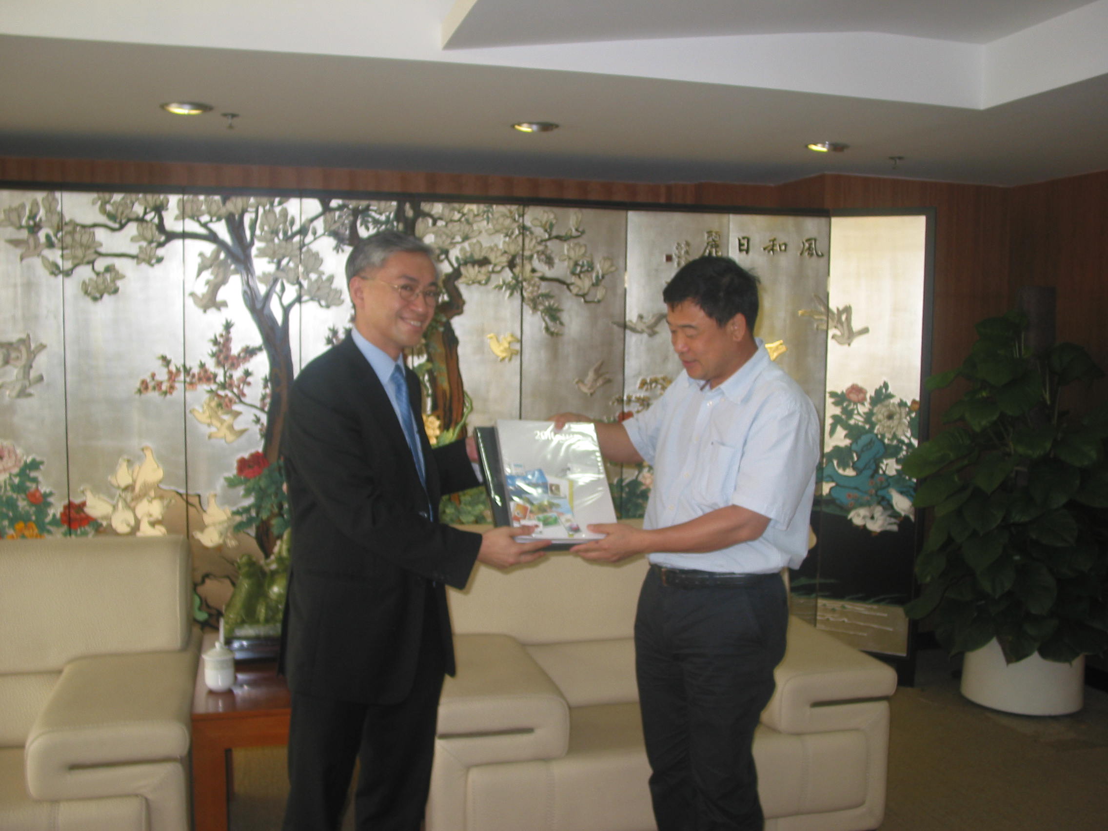 Mr. Shun (left) offered souvenir to Mr. Zhang