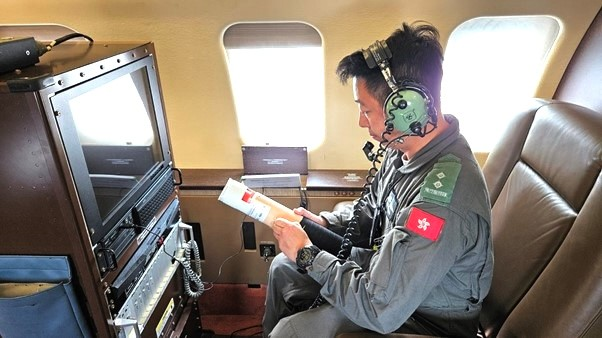 香港政府飛行服務隊機組人員在投放任務前連接下投探空儀以作檢查及設定參數