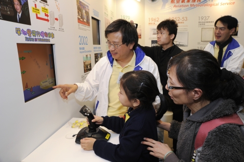 「天文台之友」義工向小朋友示範「風切變飛行」電腦遊戲。